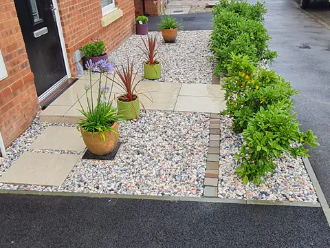 Front garden with a paved path, gravel and potted planting
