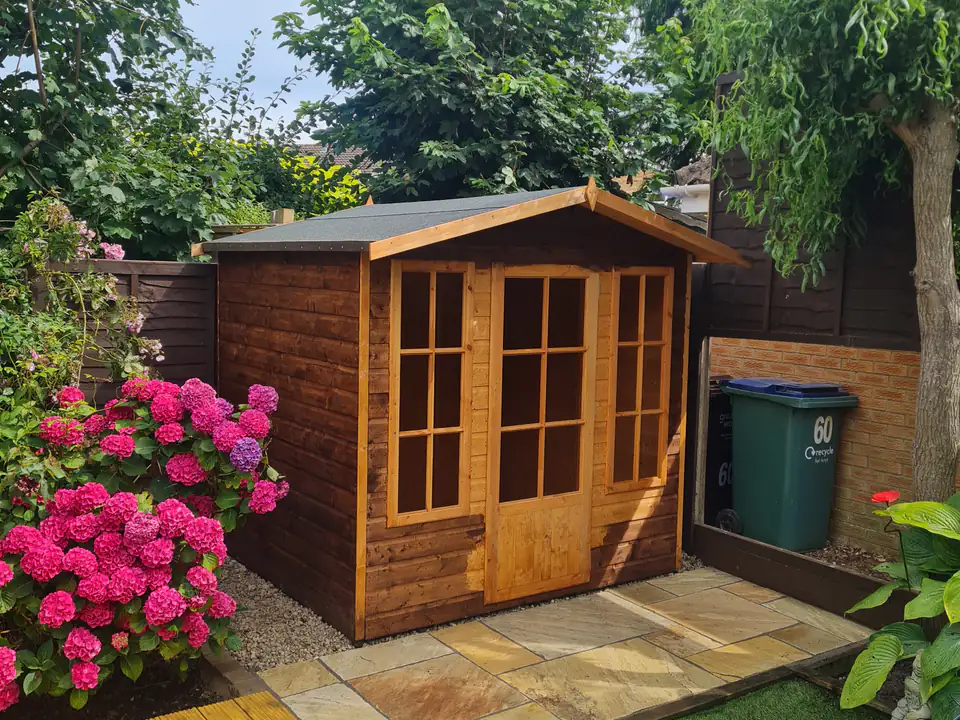 Timber summerhouse with a paved sitting area